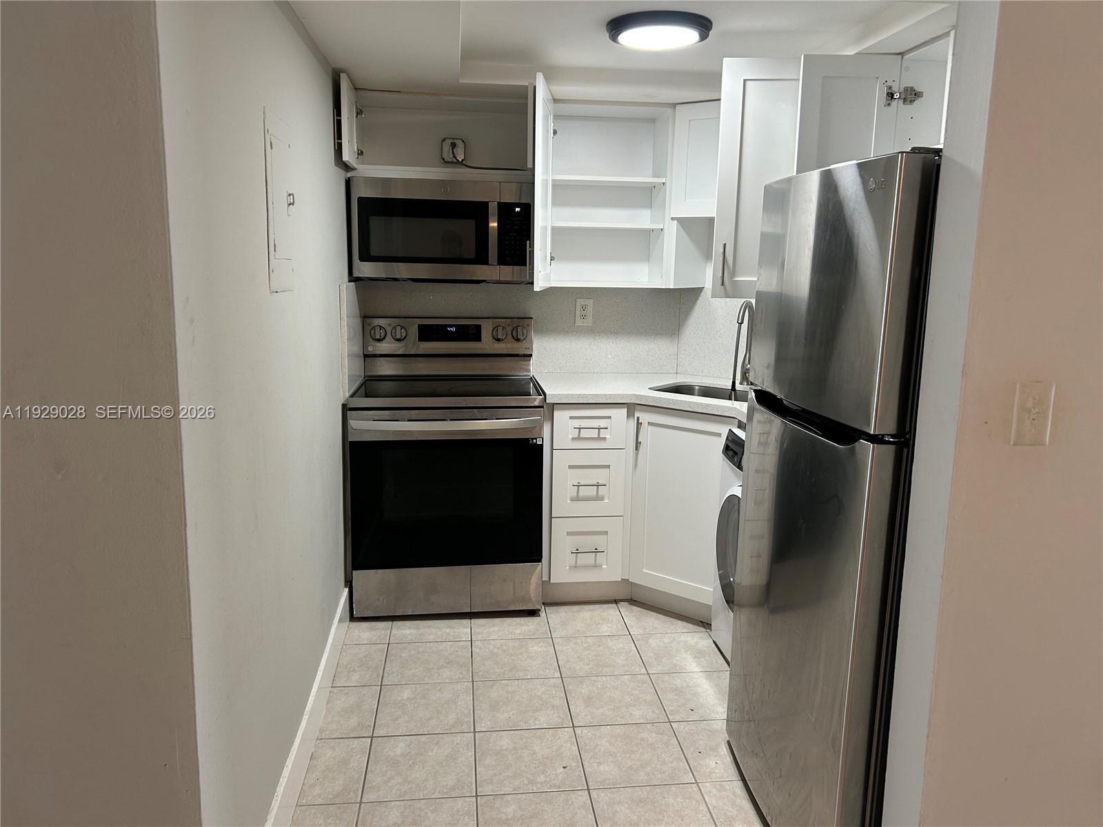 335 Southwest 20th Street, Unit 7 Fort Lauderdale, FL 33315 - Photo 3 of 17 a kitchen with a refrigerator and a stove