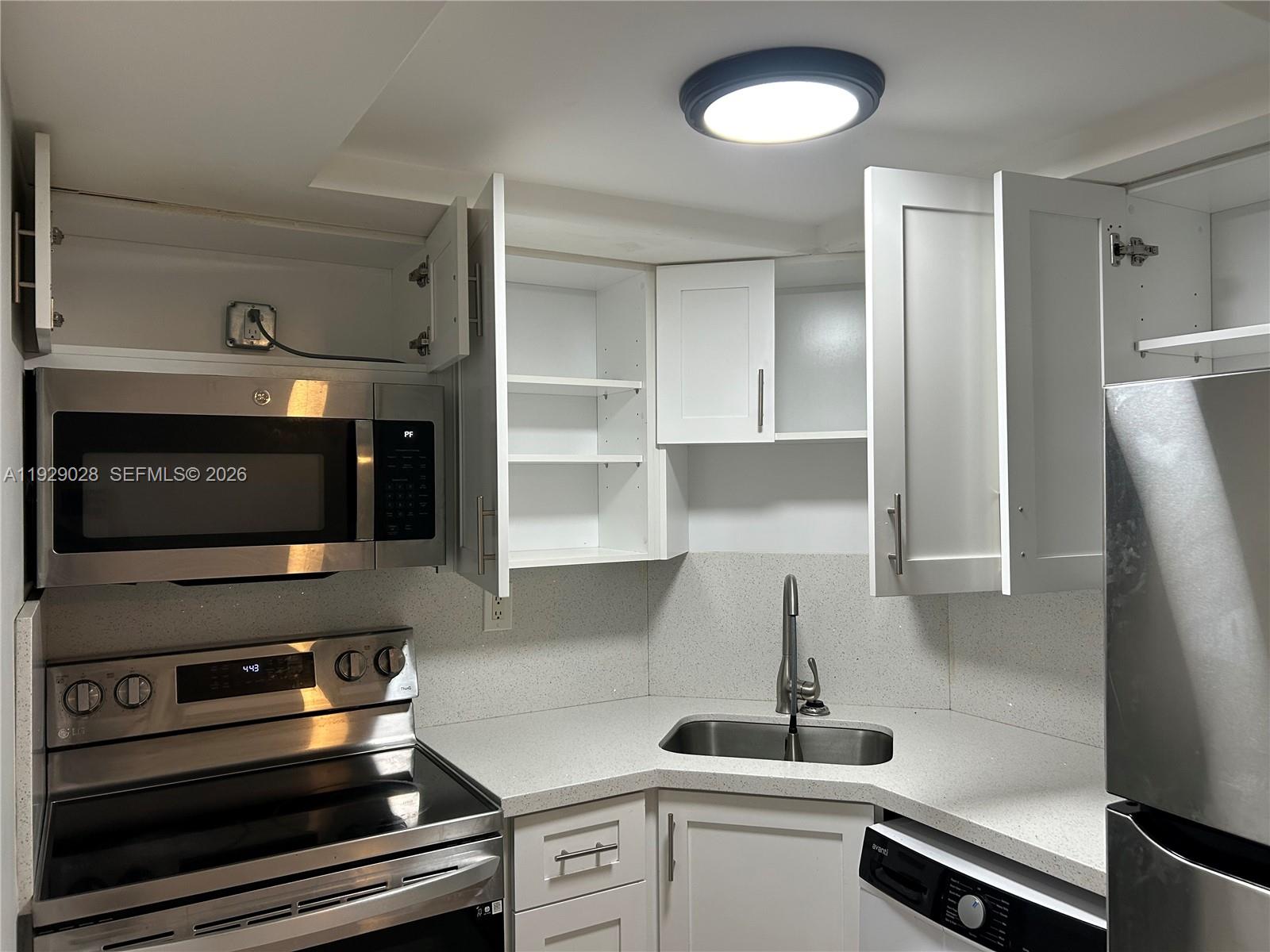 335 Southwest 20th Street, Unit 7 Fort Lauderdale, FL 33315 - Photo 4 of 17 a kitchen with appliances and cabinets