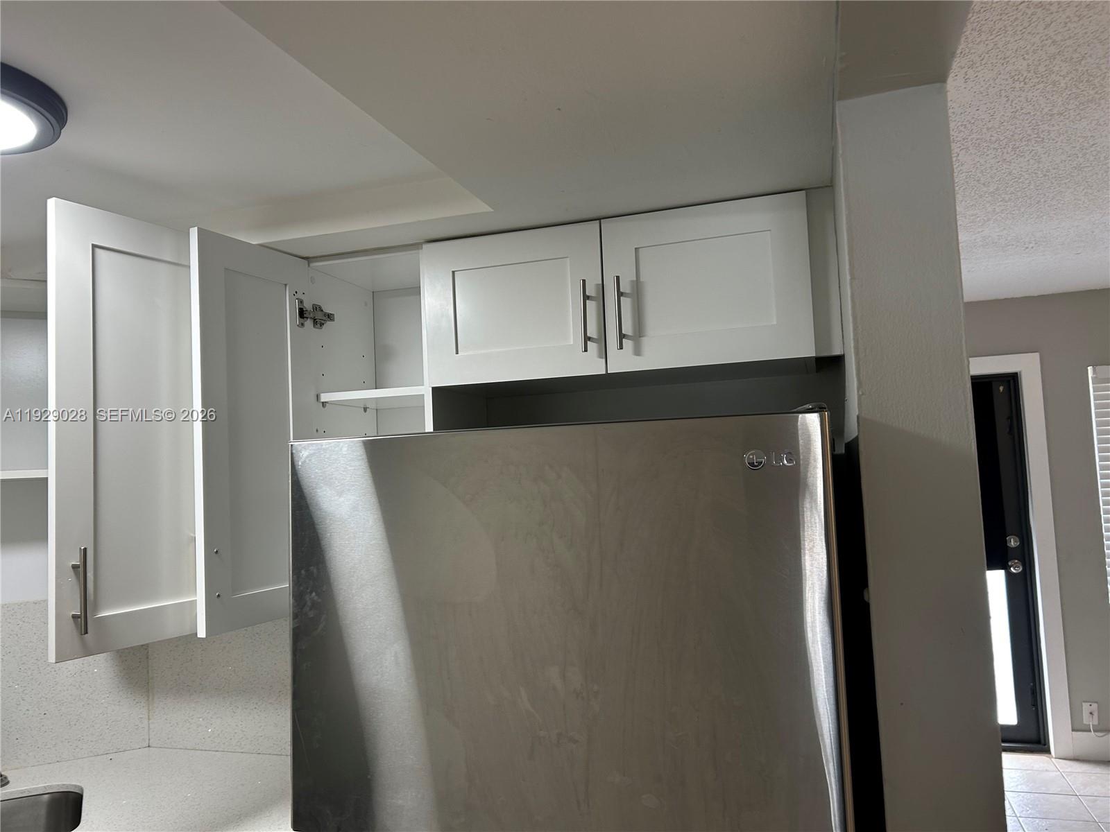 335 Southwest 20th Street, Unit 7 Fort Lauderdale, FL 33315 - Photo 6 of 17 a view of cabinets and refrigerator