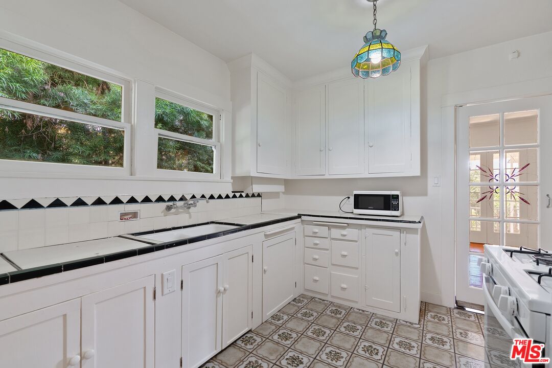 2117 Vestal Avenue Los Angeles, CA 90026 - Photo 13 of 26 a kitchen with a sink window and cabinets