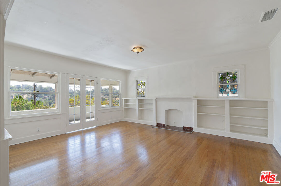 2117 Vestal Avenue Los Angeles, CA 90026 - Photo 6 of 26 wooden floor fireplace and windows in an empty room