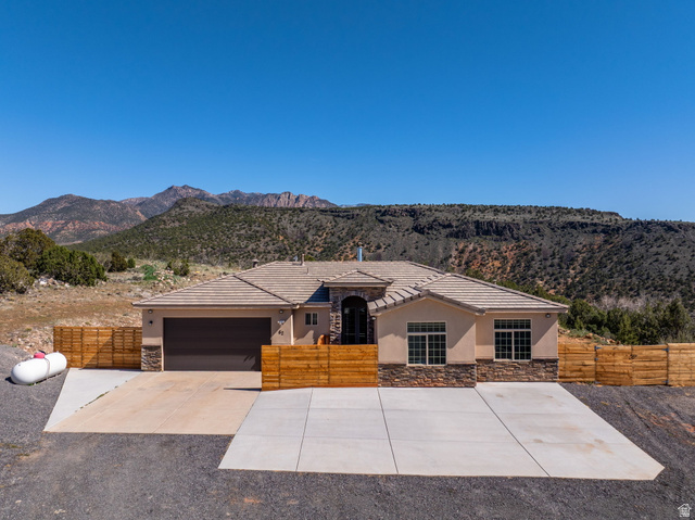 62 North Lucky 7 Road Veyo, UT 84782 - Photo 36 of 43 View of front of property featuring a fenced front yard, stone siding, stucco siding, and an attached garage