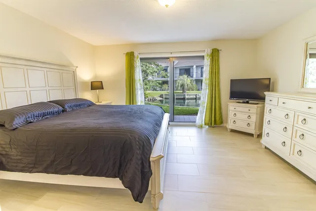 a spacious bedroom with a bed and flat screen tv