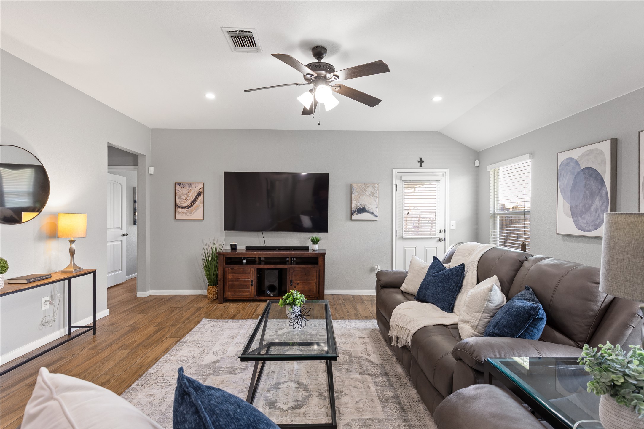 256 Alpha Kyle, TX 78640 - Photo 9 of 27 Hardwood look tile floors and vaulted ceilings create an open, airy ambiance in this living area.
