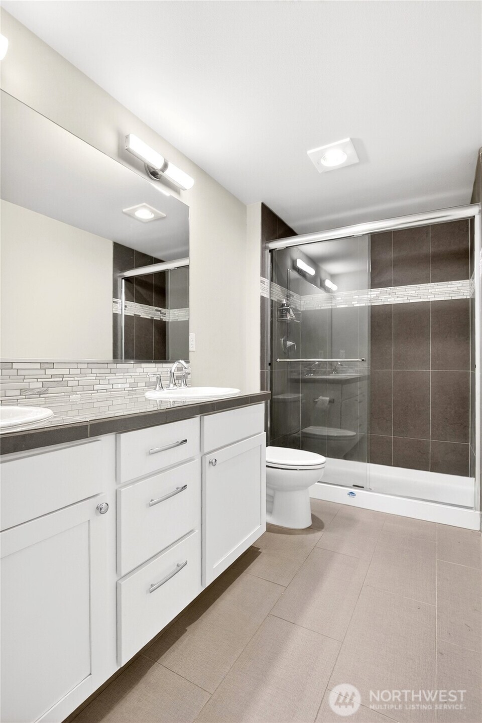 22925 79th Place West, Unit B Edmonds, WA 98026 - Photo 17 of 39 a bathroom with a granite countertop sink a toilet and a shower