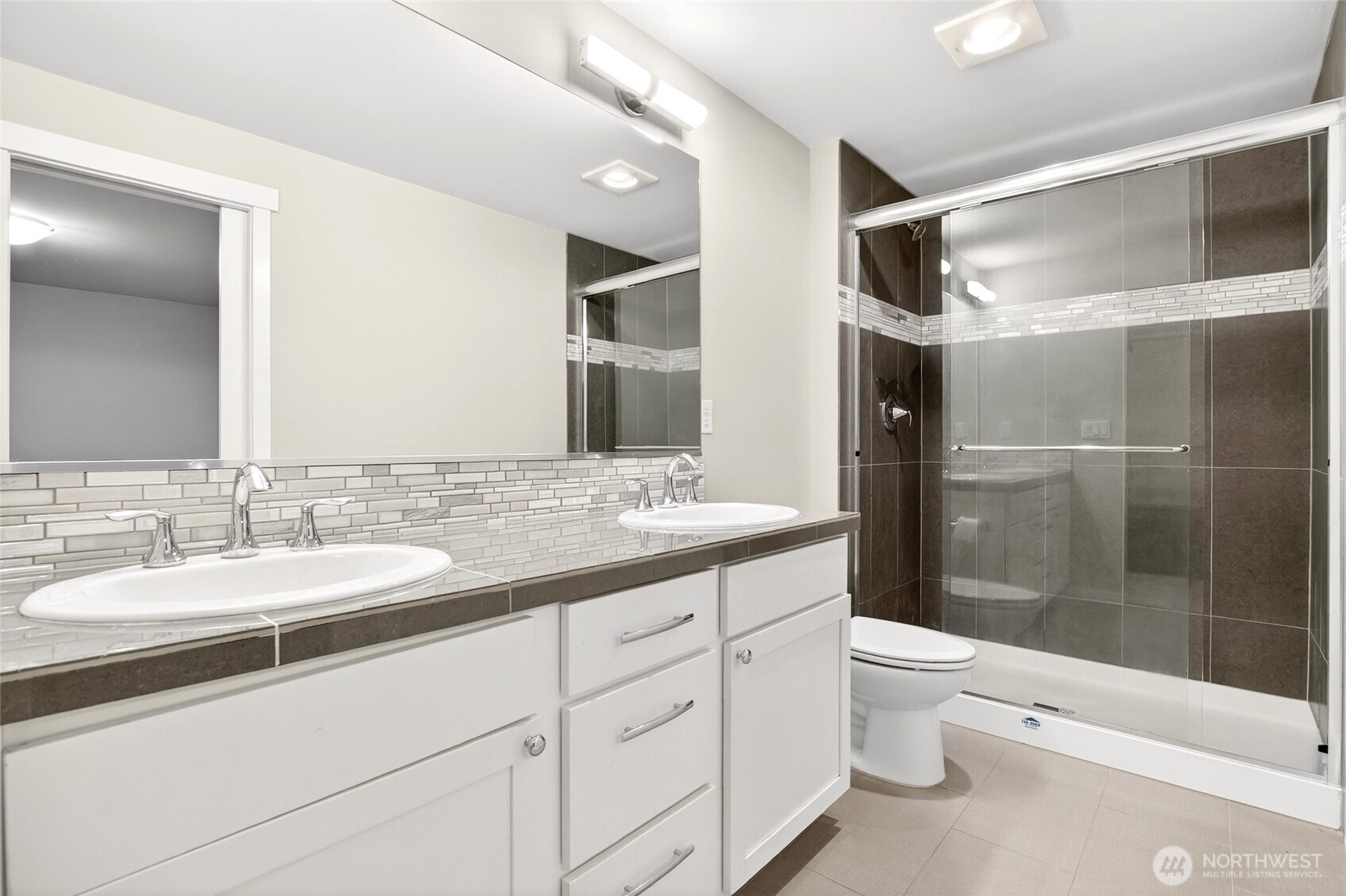 22925 79th Place West, Unit B Edmonds, WA 98026 - Photo 18 of 39 a bathroom with a double vanity sink toilet mirror and shower