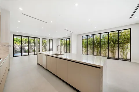 a large white kitchen with large windows