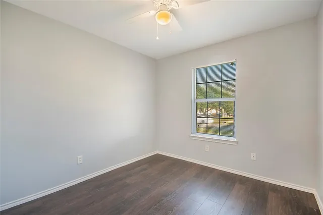 an empty room with wooden floor and a window