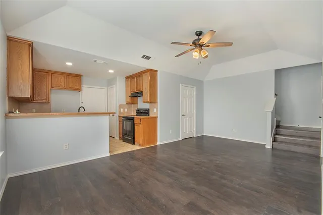 a view of a kitchen with wooden floor and a ceiling fan