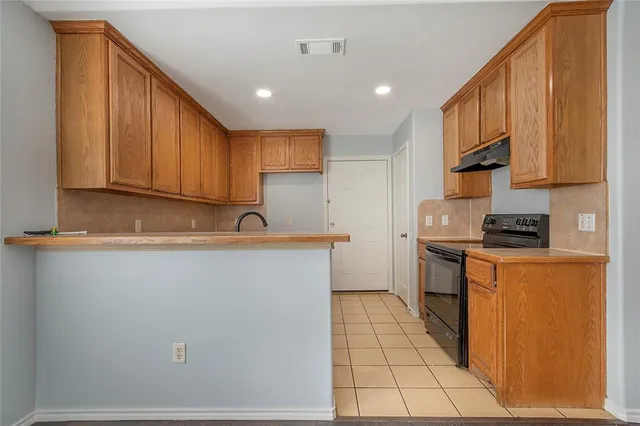 a kitchen with stainless steel appliances granite countertop a stove a sink and a refrigerator with cabinets