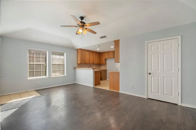 a view of a kitchen with a sink dishwasher and a kitchen area with wooden floor