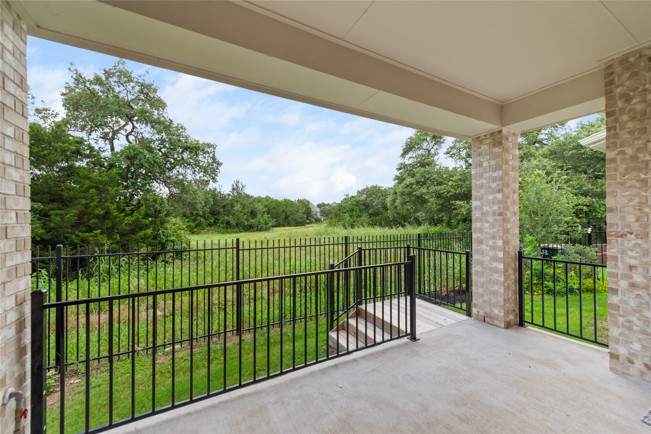 294 Kimble Creek Loop Kyle, TX 78640 - Photo 27 of 40 A spacious covered patio offers sweeping views of the verdant yard and natural surroundings.
