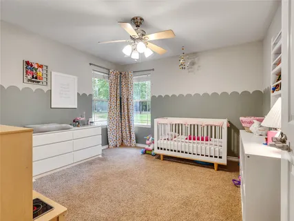 a spacious bedroom with a large bed and a chandelier