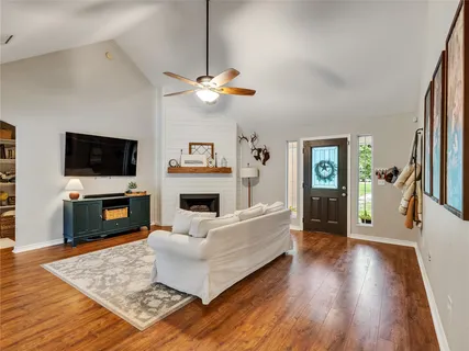 a living room with furniture a fireplace and a flat screen tv