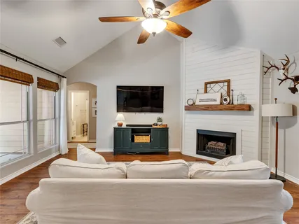 a living room with furniture a fireplace and a flat screen tv