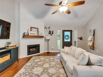 a living room with furniture a flat screen tv and a fireplace