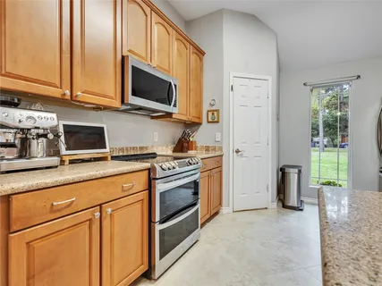 a kitchen with stainless steel appliances granite countertop a stove a sink and a microwave