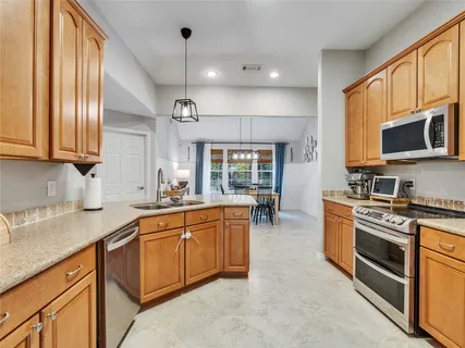 a kitchen with stainless steel appliances granite countertop a stove sink microwave and cabinets