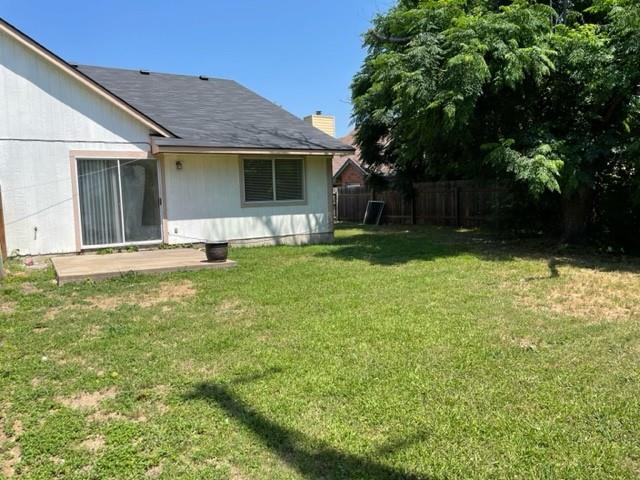 12403 Turtle Rock Road, Unit A Austin, TX 78729 - Photo 14 of 14 A spacious, grassy backyard offers a concrete patio and mature trees, perfect for outdoor enjoyment.