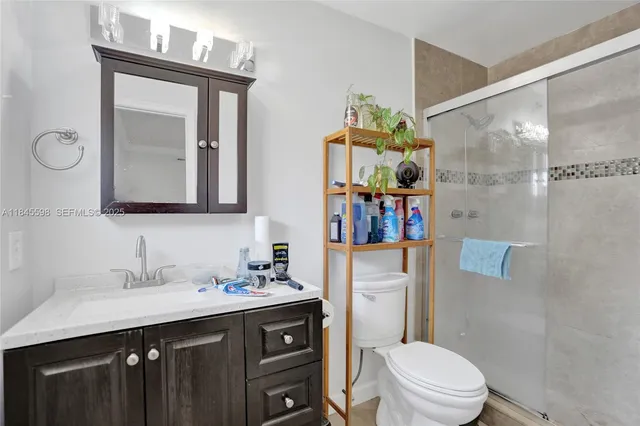 a bathroom with a sink vanity mirror and toilet