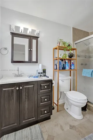 a bathroom with a sink vanity mirror and toilet