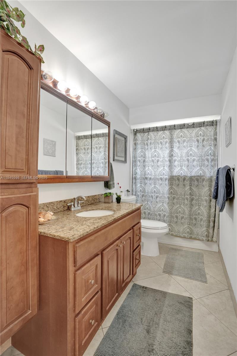 520 Southwest 62nd Avenue Margate, FL 33068 - Photo 17 of 34 a bathroom with a granite countertop sink a toilet a mirror and shower