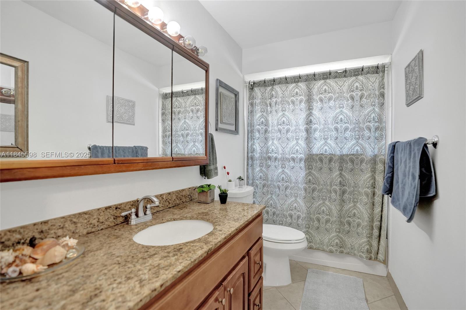 520 Southwest 62nd Avenue Margate, FL 33068 - Photo 18 of 34 a bathroom with a granite countertop sink a toilet a mirror and shower