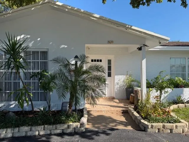 a view of a house with a yard and potted plants