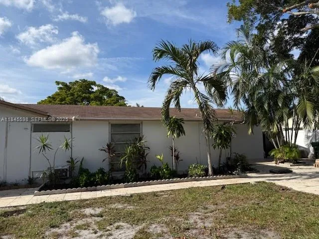a view of a house with a yard and potted plants