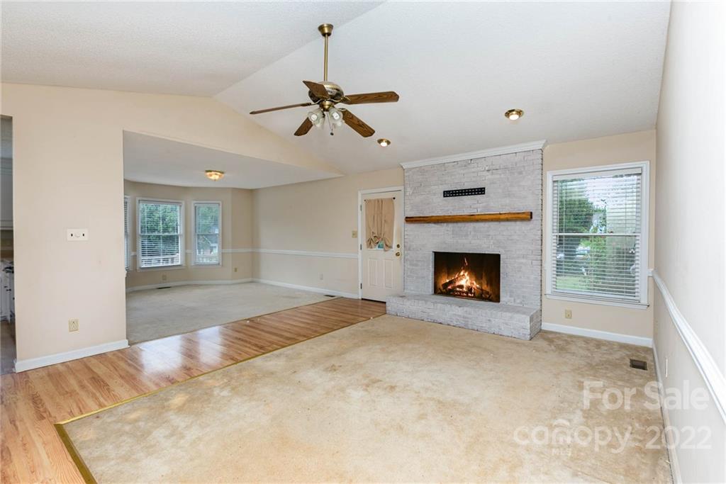 901 Stevens Road Monroe, NC 28110 - Photo 8 of 28 a view of a livingroom with a fireplace a ceiling fan and windows
