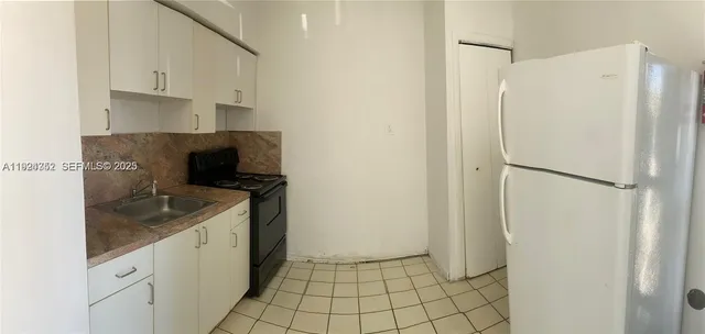 a kitchen with a refrigerator and a sink