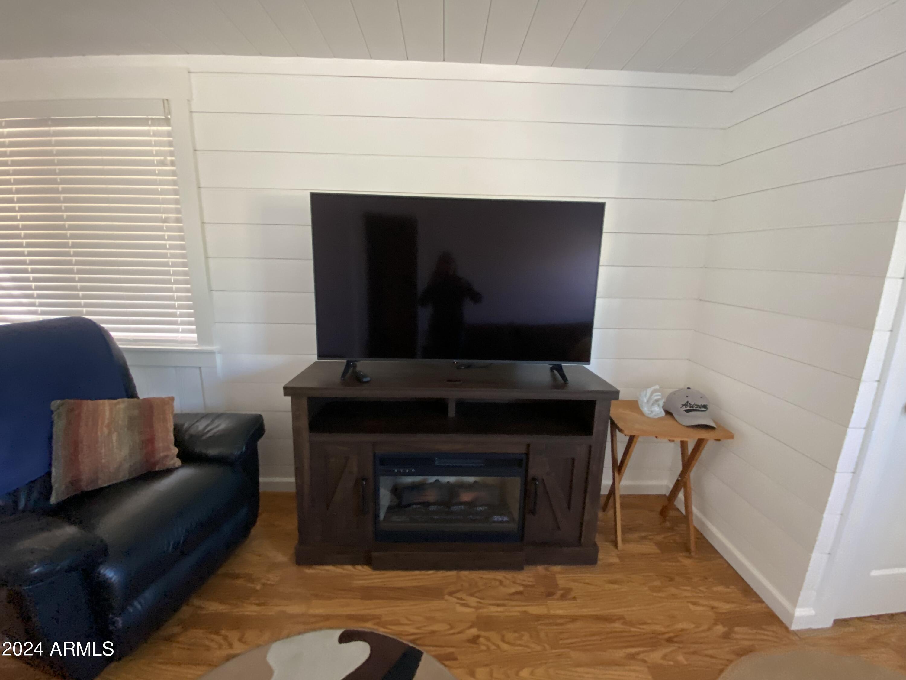 2086 West Klamath Avenue, Unit 86 Apache Junction, AZ 85119 - Photo 3 of 17 a living room with furniture a flat screen tv and a fireplace