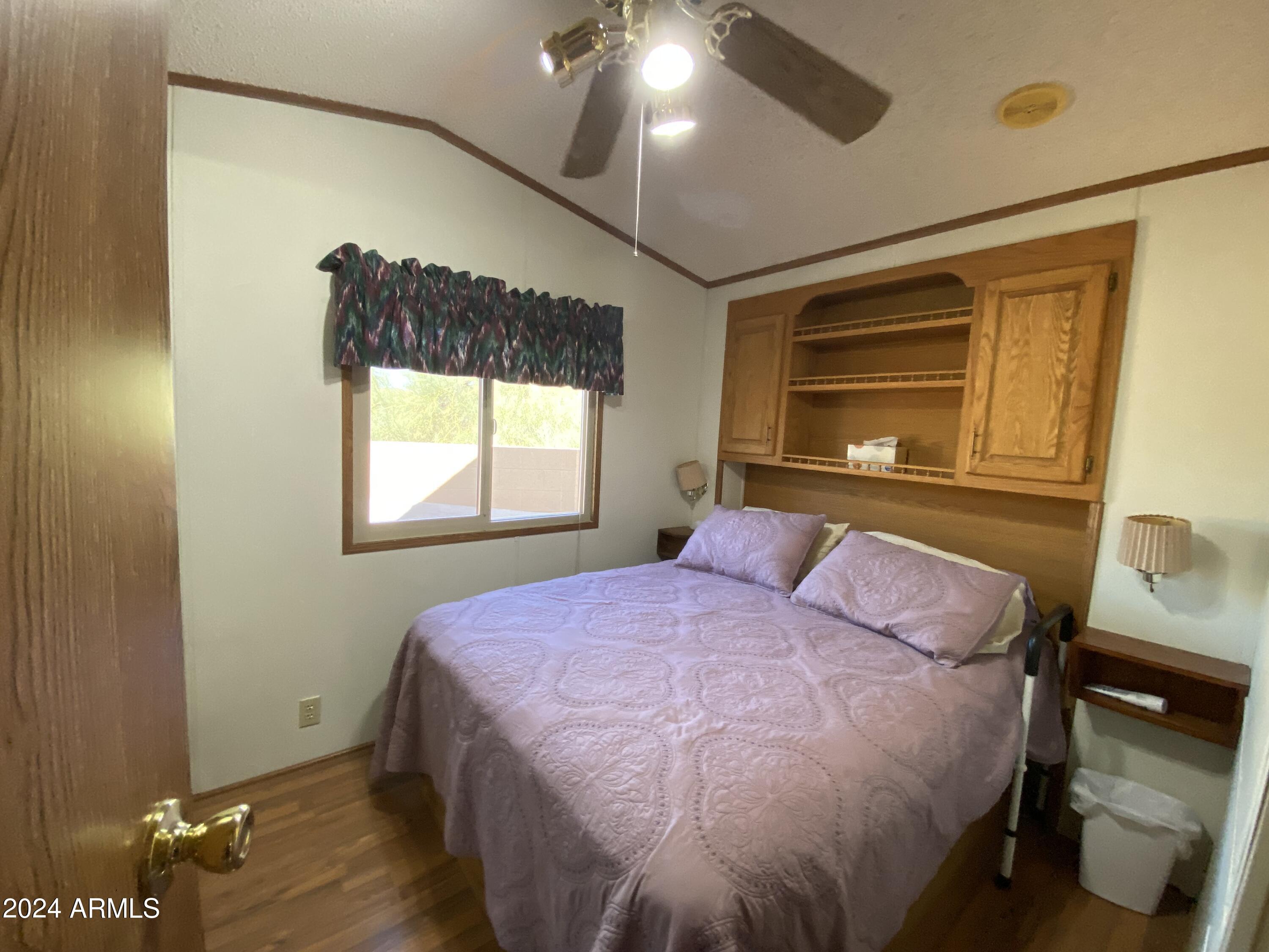 2086 West Klamath Avenue, Unit 86 Apache Junction, AZ 85119 - Photo 5 of 17 a bedroom with a bed and wooden floor