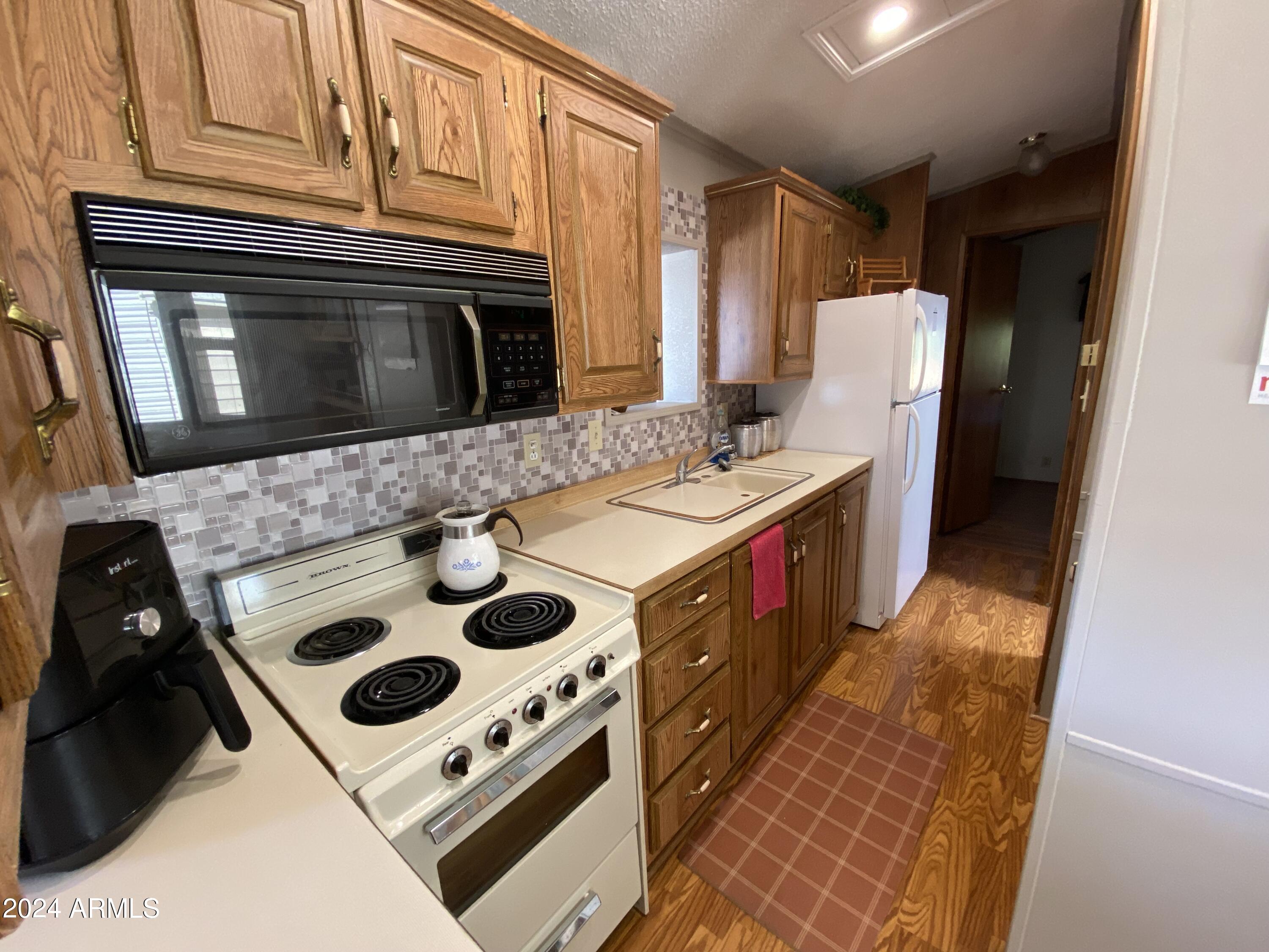 2086 West Klamath Avenue, Unit 86 Apache Junction, AZ 85119 - Photo 9 of 17 a kitchen with a stove and a refrigerator