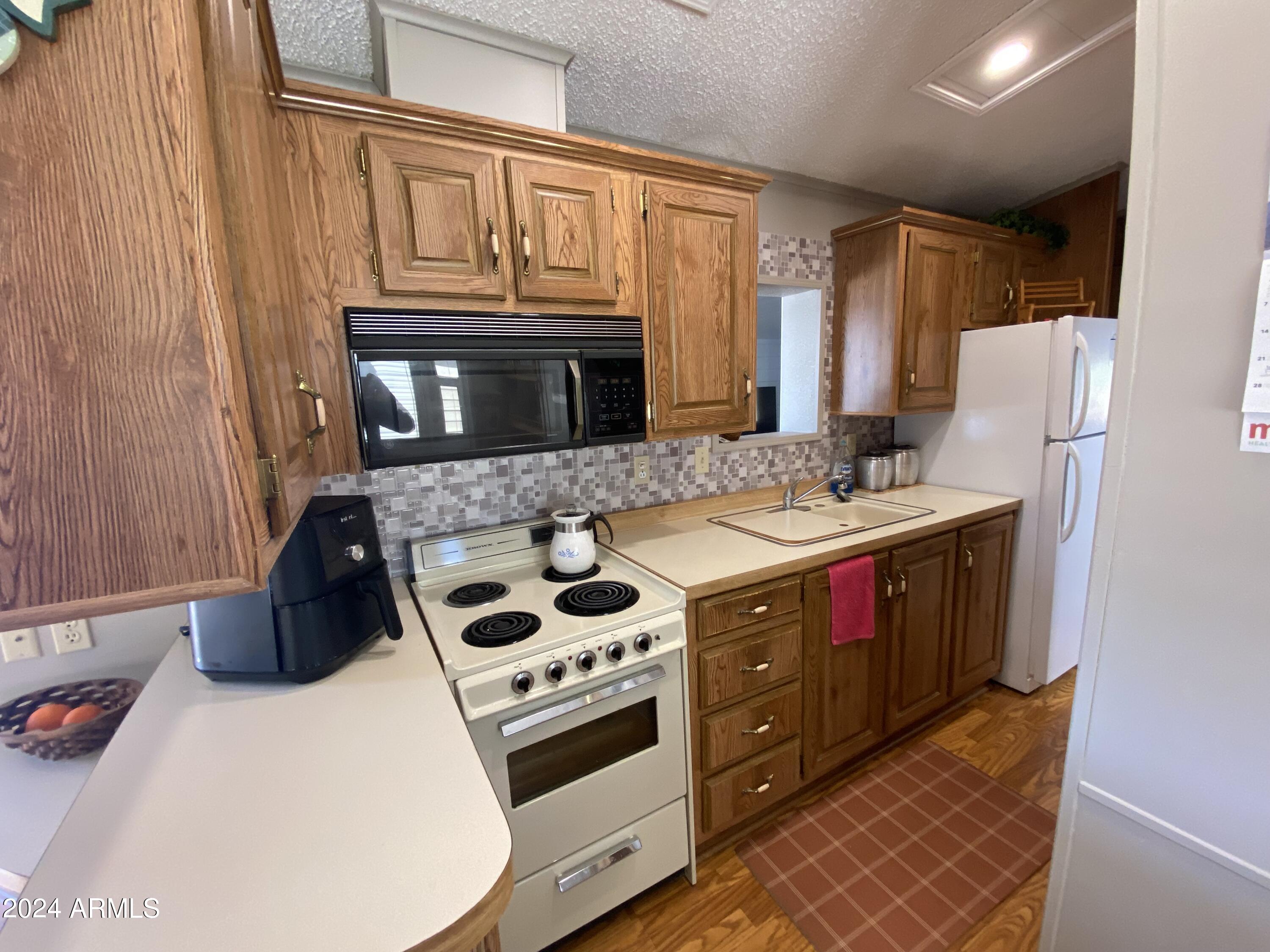 2086 West Klamath Avenue, Unit 86 Apache Junction, AZ 85119 - Photo 10 of 17 a kitchen with stainless steel appliances granite countertop a stove a sink and a microwave