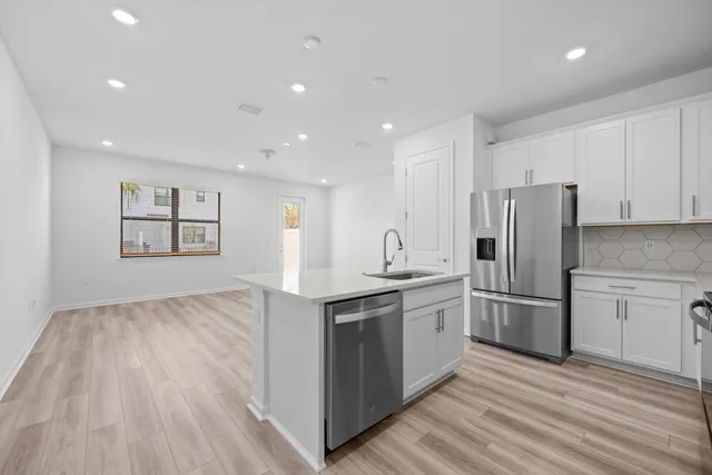 a kitchen with stainless steel appliances granite countertop a refrigerator and a stove top oven