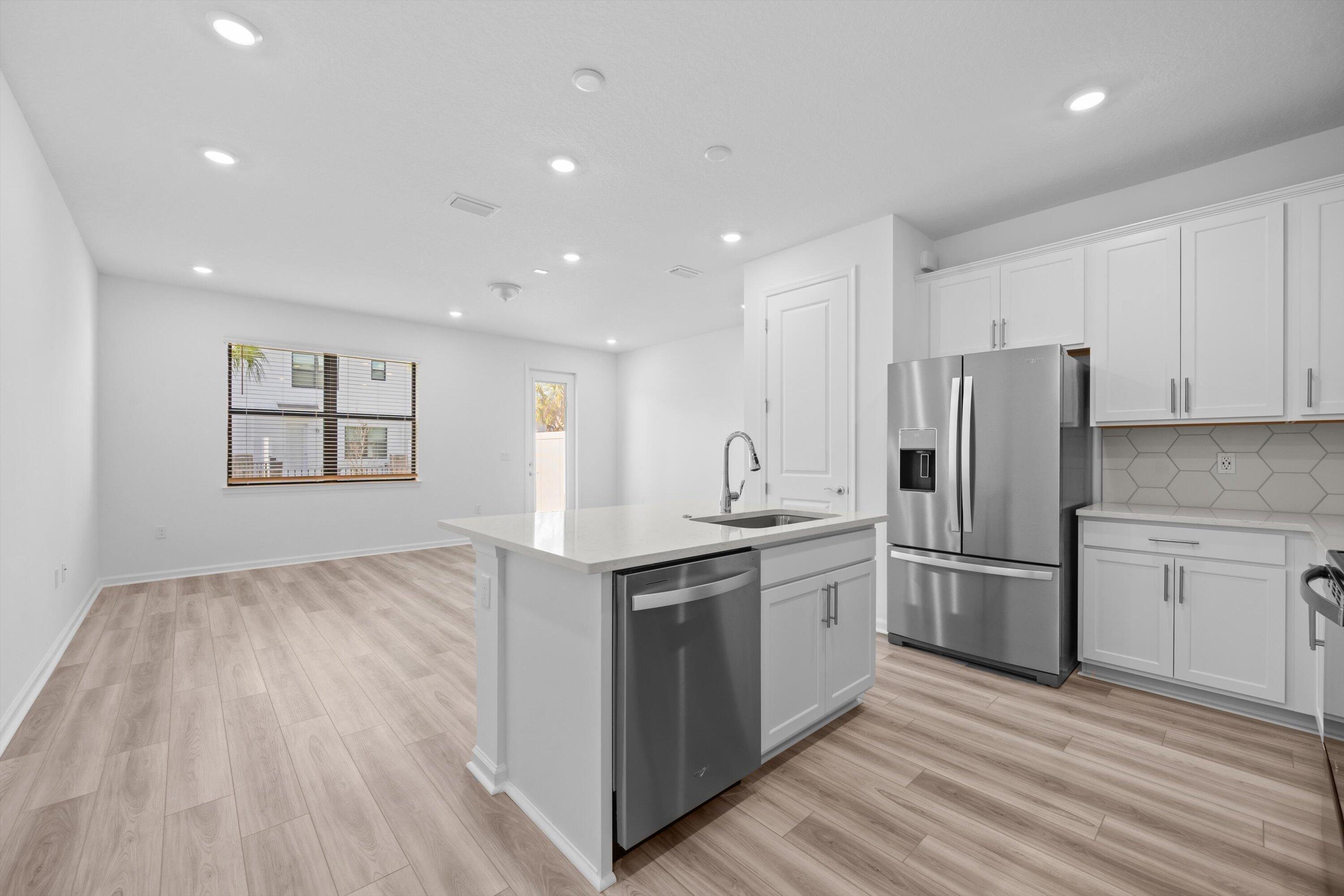 7638 Southwest Lucy Lane Stuart, FL 34997 - Photo 11 of 45 a kitchen with stainless steel appliances granite countertop a refrigerator and a stove top oven