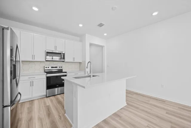 a kitchen with stainless steel appliances a sink stove and refrigerator