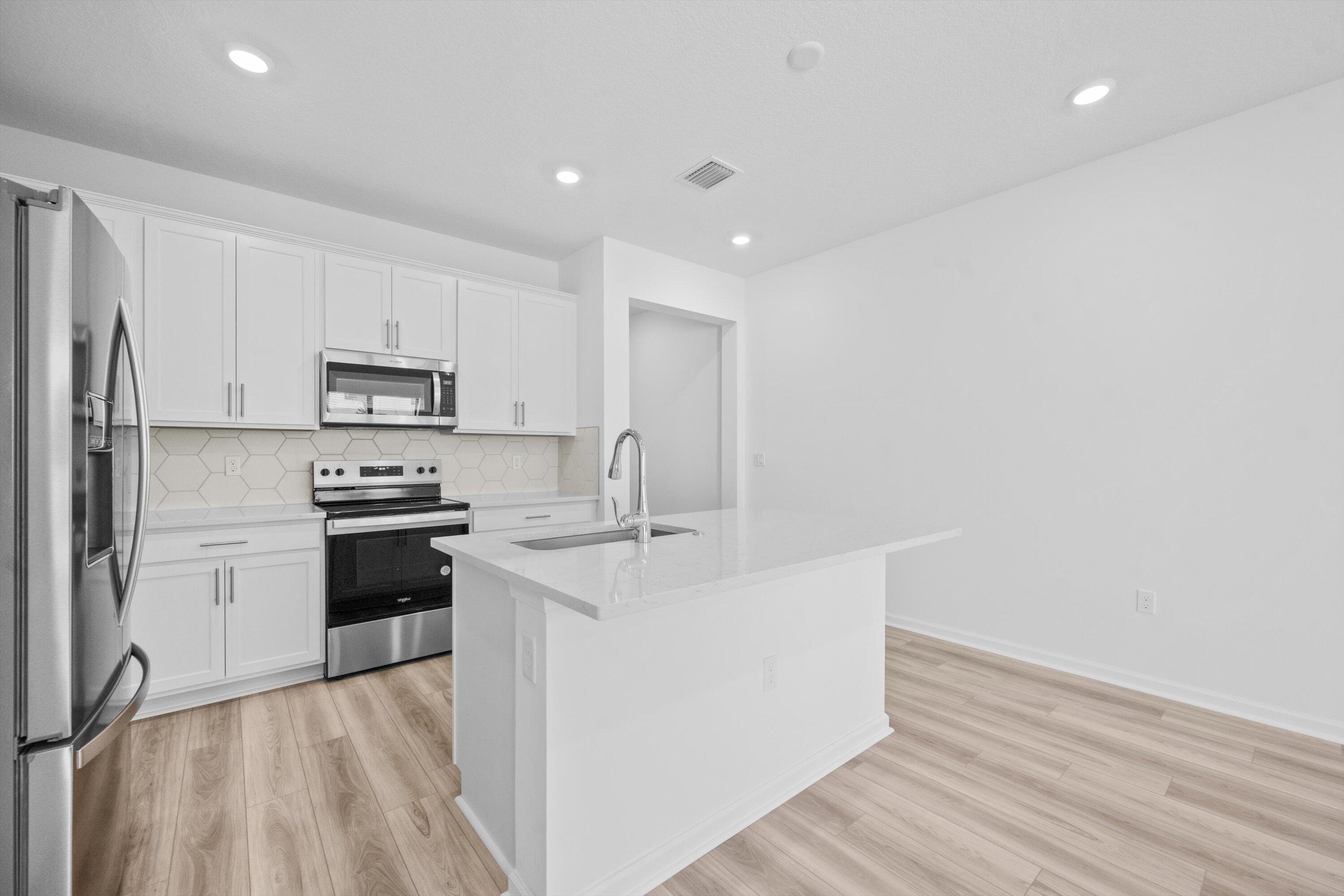 7638 Southwest Lucy Lane Stuart, FL 34997 - Photo 15 of 45 a kitchen with stainless steel appliances a sink stove and refrigerator