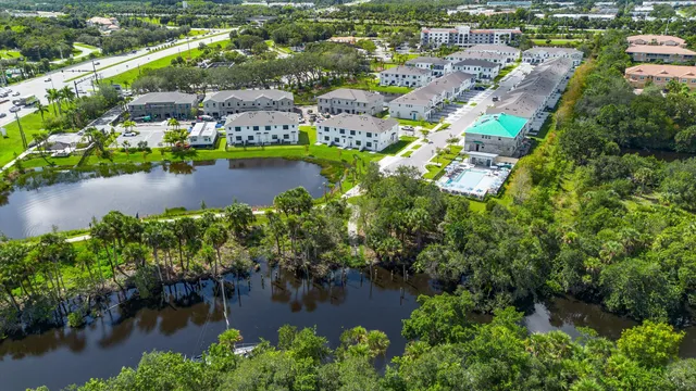 an aerial view of residential houses with outdoor space and lake view