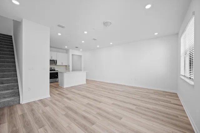 a view of a kitchen with wooden floor and a window