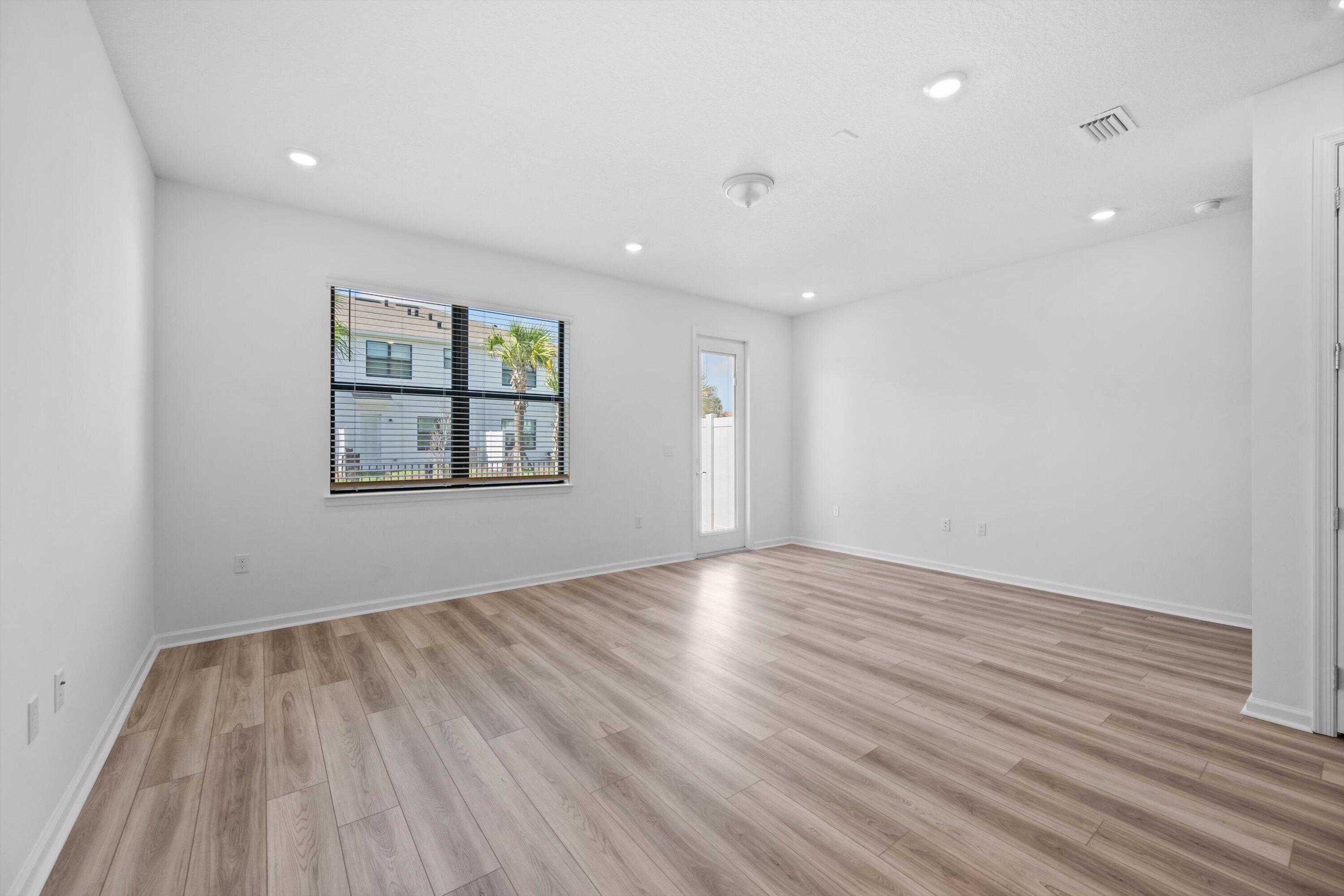 7638 Southwest Lucy Lane Stuart, FL 34997 - Photo 10 of 45 an empty room with wooden floor and windows