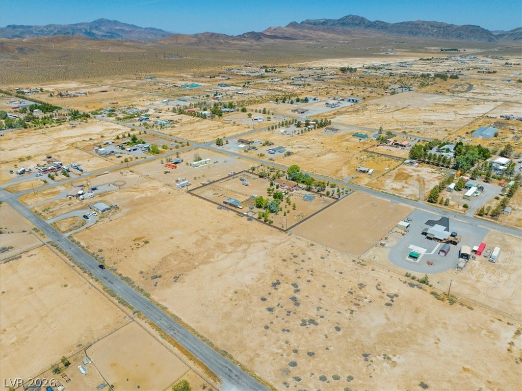 4610 Lawrence Road Pahrump, NV 89048 - Photo 34 of 42 An aerial perspective reveals a vast desert landscape dotted with residential properties and distant mountains.