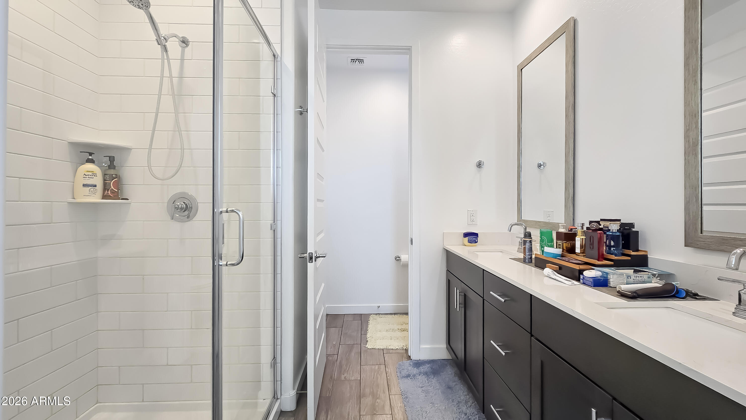16839 West Evergreen Road Waddell, AZ 85355 - Photo 16 of 28 a bathroom with a double vanity sink a mirror and a shower