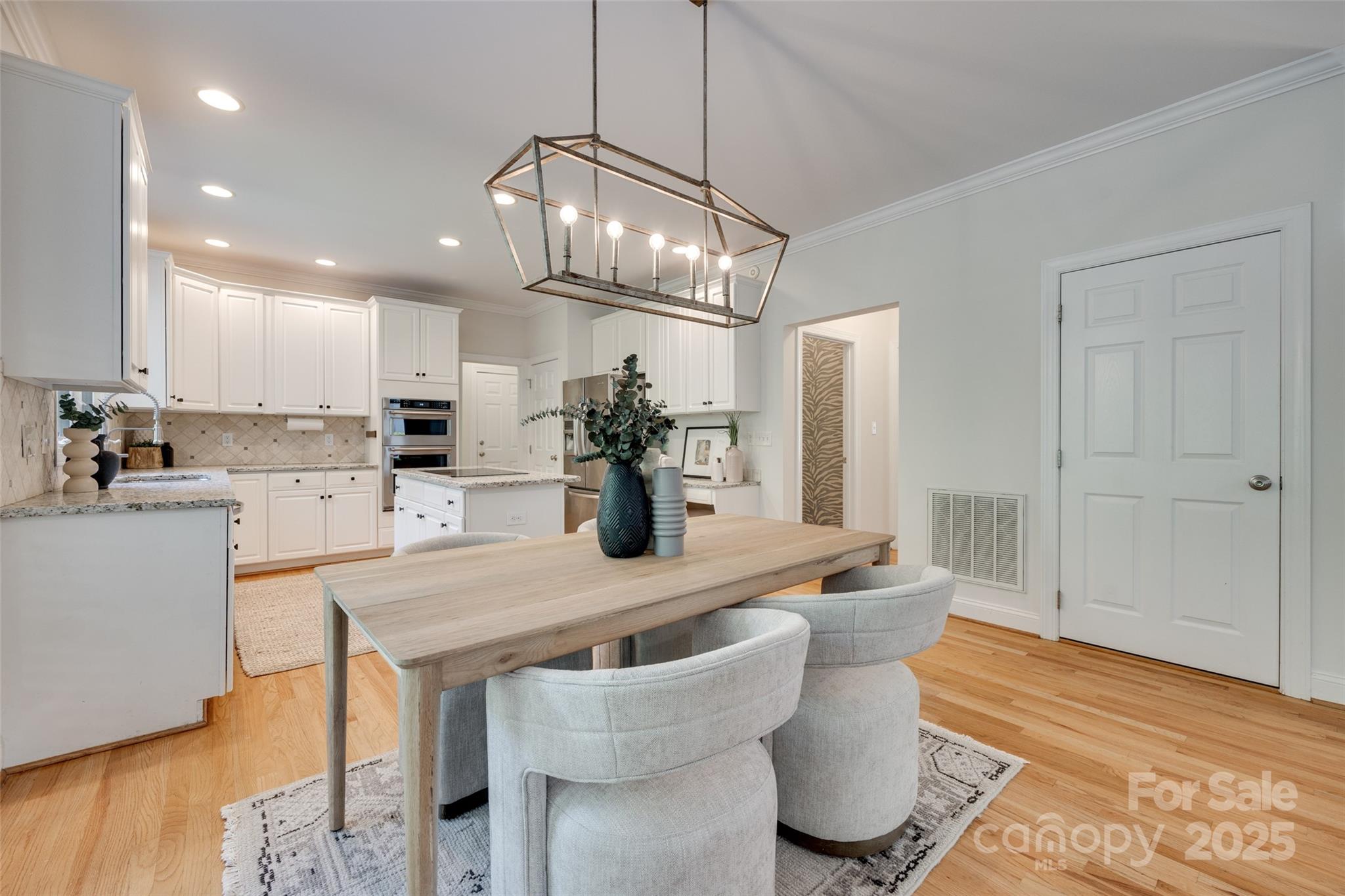 6804 Riesman Lane Charlotte, NC 28210 - Photo 13 of 46 a kitchen with stainless steel appliances kitchen island granite countertop a dining table chairs and white cabinets