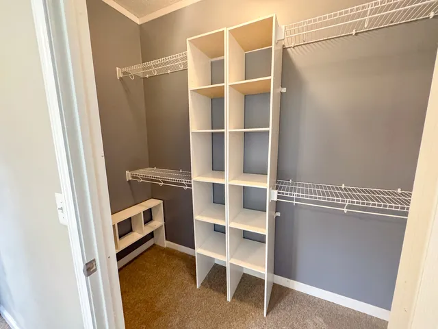a view of walk in closet with empty racks