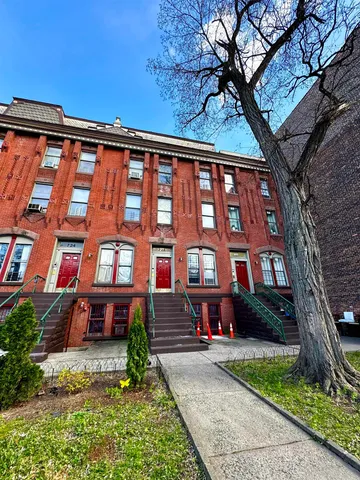 front view of a brick house with a yard