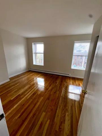 a view of room with window and wooden floor