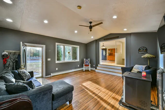a spacious bedroom with a large bed a chandelier and dresser