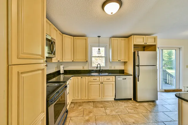 a kitchen with stainless steel appliances granite countertop a sink and cabinets